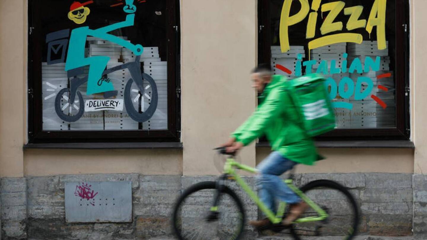 FILE PHOTO: A delivery person rides a bicycle past a restaurant, amid the outbreak of the coronavirus disease (COVID-19) in Saint Petersburg, Russia June 5, 2020.
