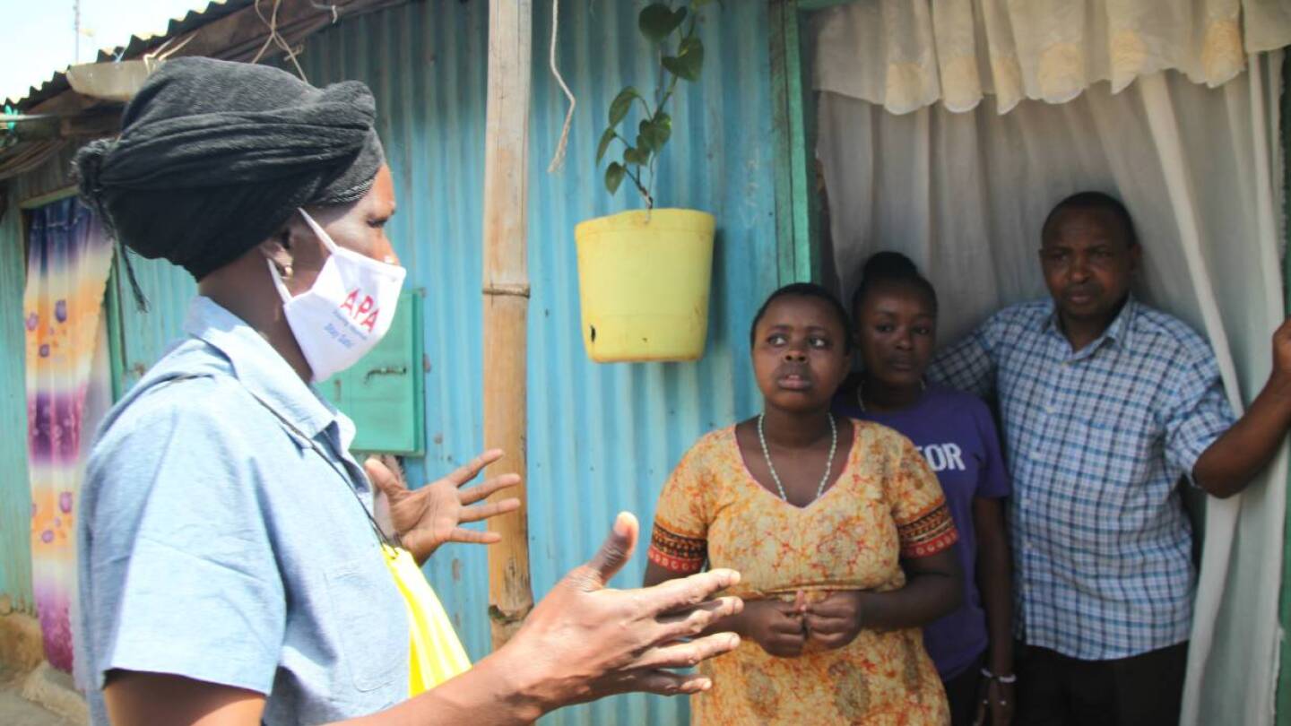 Community health volunteer Everlyne Akinyi Omondi talks to residents about the dangers of COVID-19 in Kawangware informal settlement in Nairobi, Kenya on May 27, 2020. | THOMSON REUTERS FOUNDATION/Nita Bhalla