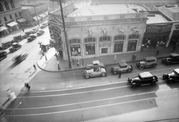 1933 view of the southwest corner of the intersection. By the time of this photo, a fur shop had replaced the Hellman Bank branch as the building's primary tenant. Courtesy of the Dick Whittington Photography Collection, USC Libraries.