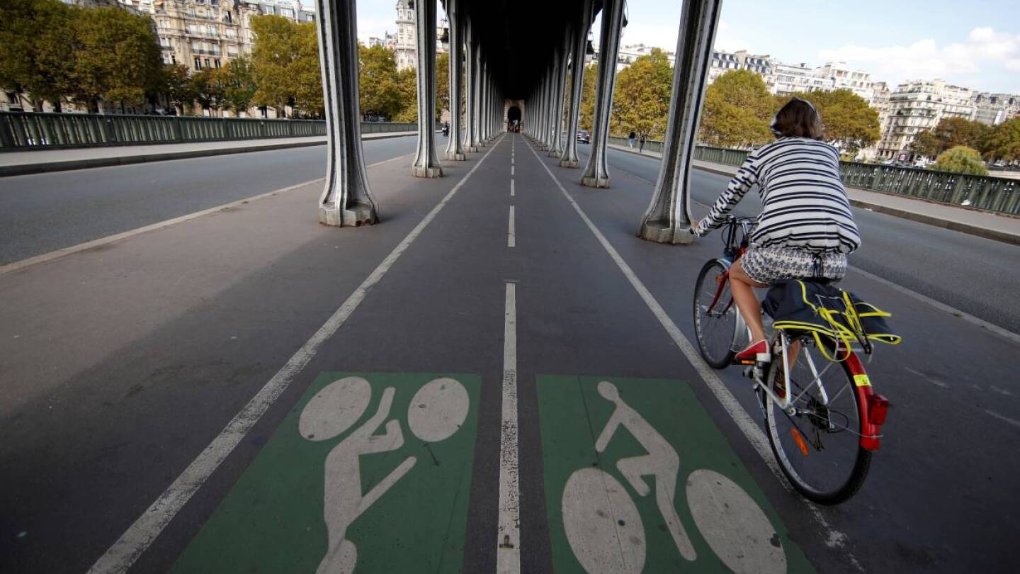 ARCHIVE PHOTO: A woman rides a bicycle along a bike path on the Pont de Bir-Hakeim bridge in Paris, France, September 14, 2018. | REUTERS/Gonzalo Fuentes