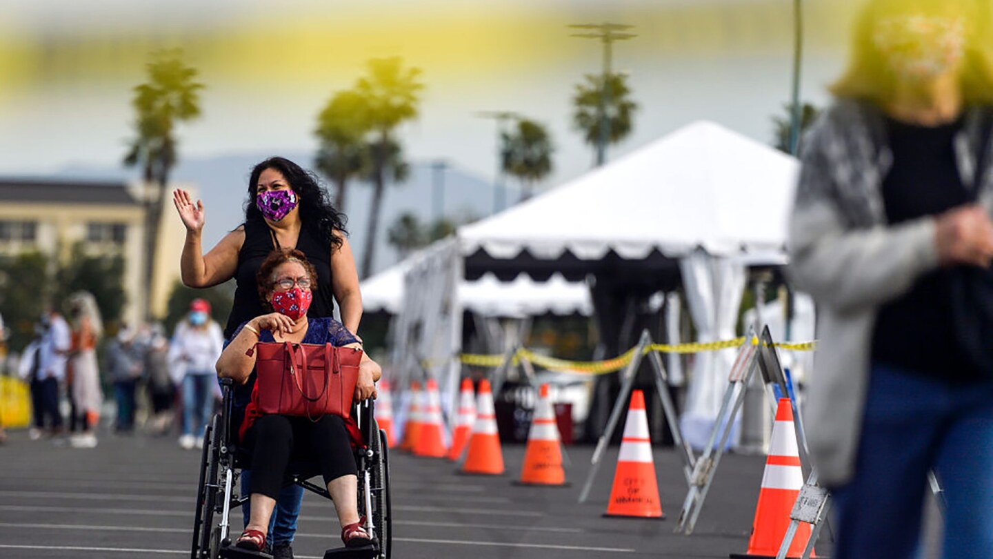 People exit the COVID-19 vaccine super site set up at the north of the Toy Story Parking Lot at the Disneyland Resort in Anaheim, California, on Jan. 13, 2021.