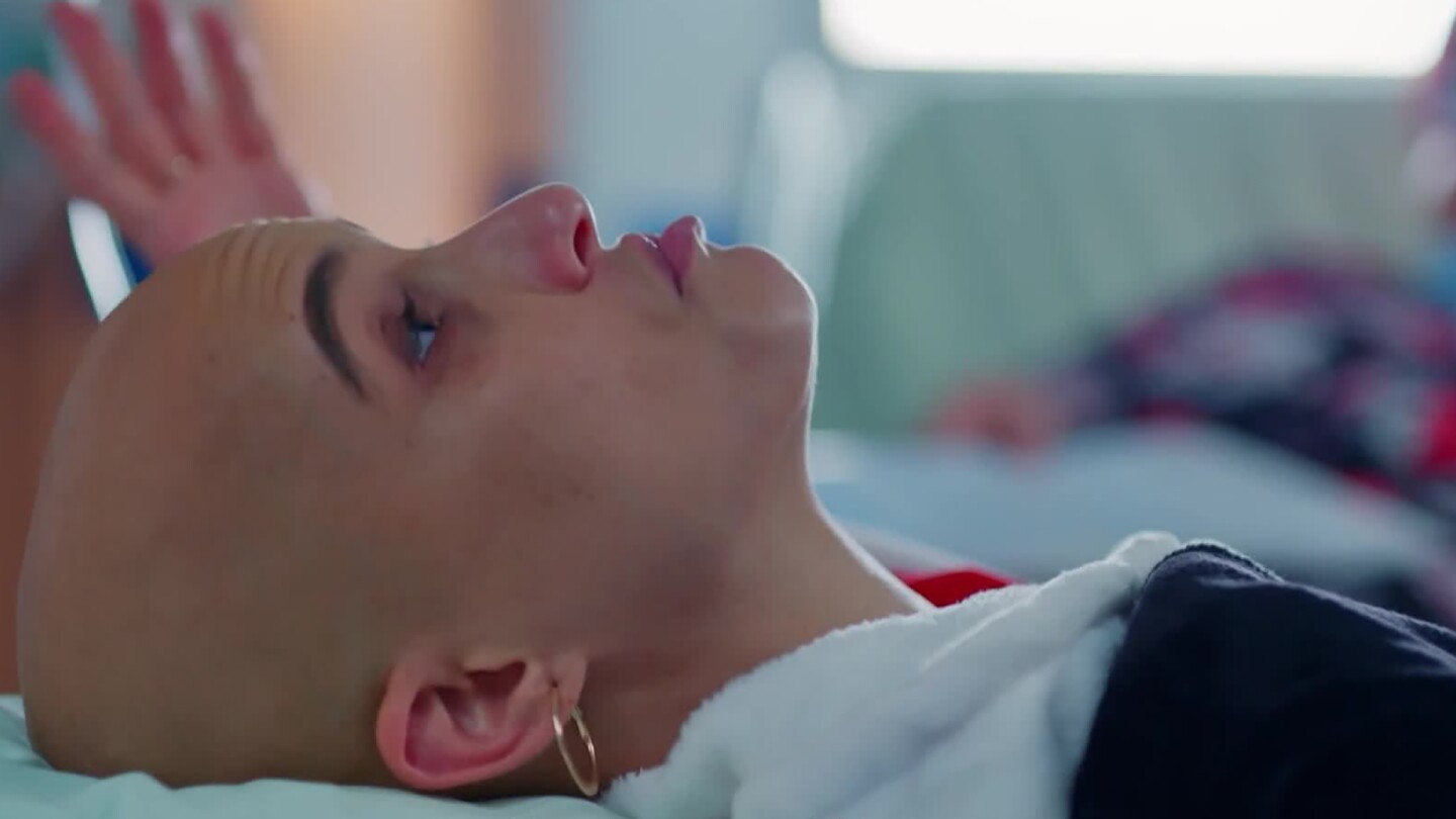 Michal lies in a hospital bed.