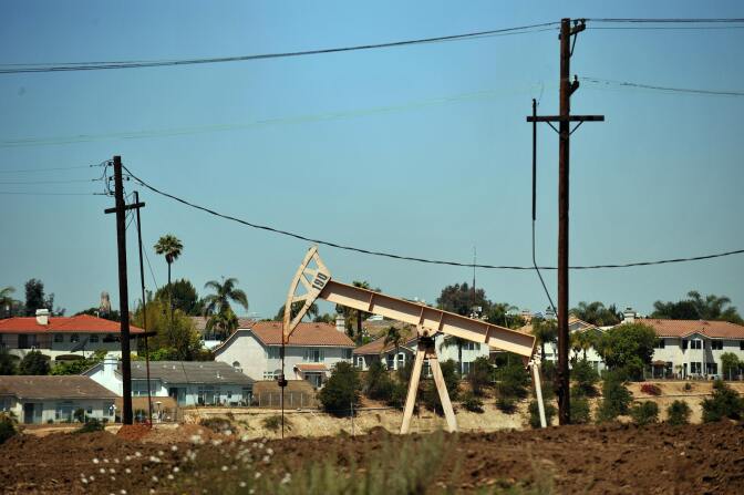 an oil rig in front of homes