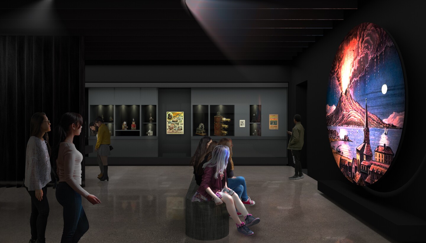 A rendering of "The Path to Cinema: Highlights from the Richard Balzer Collection," an exhibition at the Academy Museum of Motion Pictures set to open Sept. 30. The image depicts museum-goers in a dark room viewing a circular screen displaying an image of an erupting volcano.
