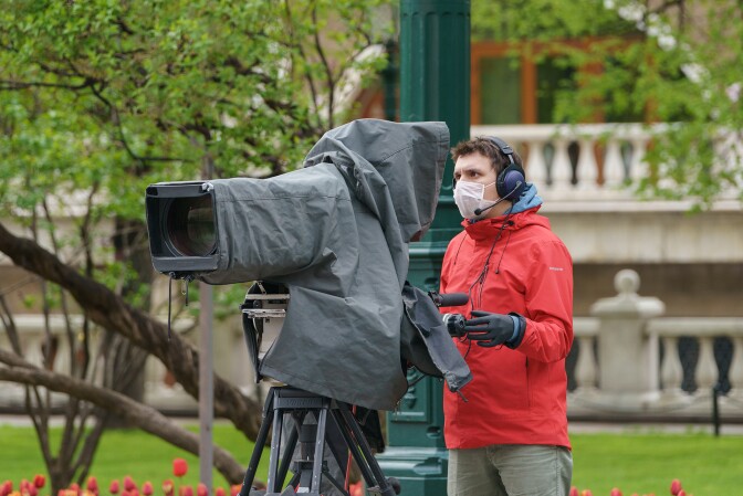 The celebration of Victory Day, May 2020 in Moscow, Russia, during coronavirus pandemic time. Holidays in protective face masks. Young TV operator working in the city center. | Yury Karamanenko/iStockphoto