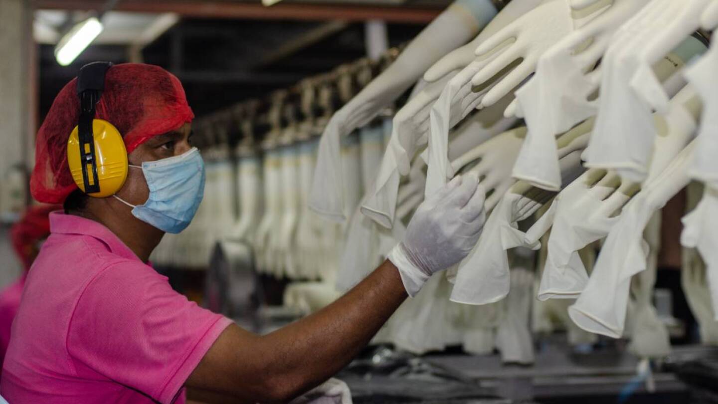 A worker makes checks at the Miditech Gloves' rubber glove factory in Malaysia in 2020. | Miditech Gloves via Thomson Reuters Foundation