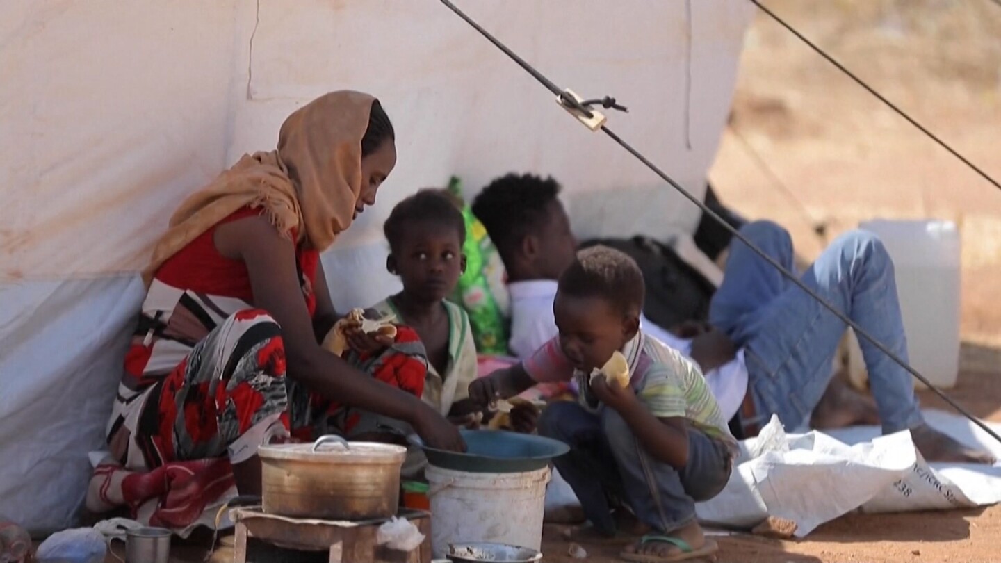 A small family in Ethiopia's Tigray region eat bread against a tent.