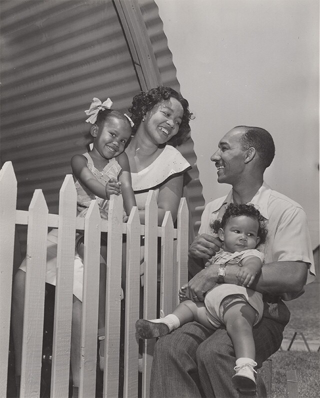 Mother and father holding children at Roger Young Village | Housing Authority of the City of Los Angeles