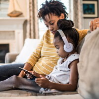 Mother and daughter on couch using tablet