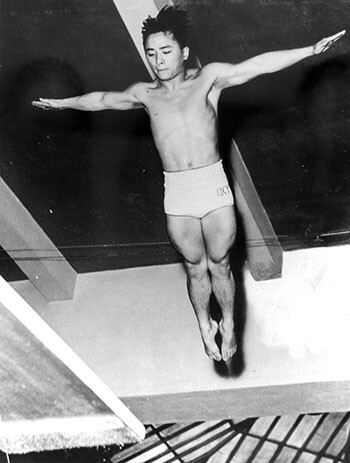 Sammy Lee, wearing Oxy trunks, dives