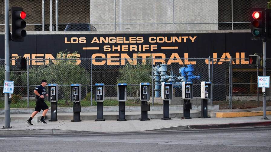 A man jogs past a row of telephone booths in front of the Los Angeles County Men's Central Jail on May 11, 2020 in Los Angeles.