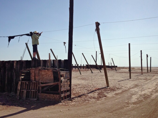 Photographer on desert ruin capturing first image in article. Salton Sea, CA. 2014. | Photo: Christopher Langley.