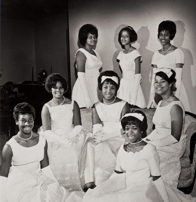 African American debutantes gather around for a photo.