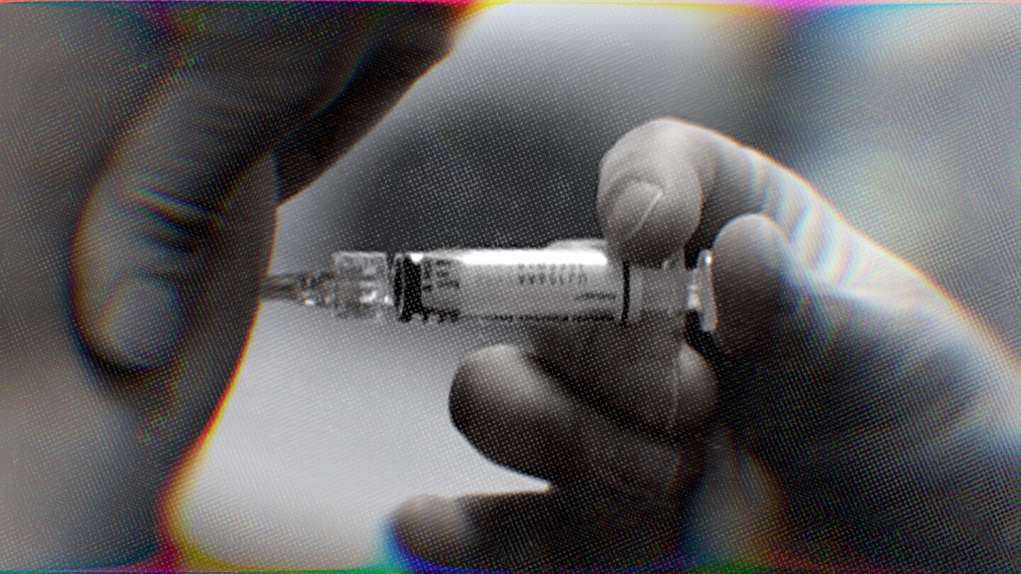 A person injects a vaccine into another person's arm.