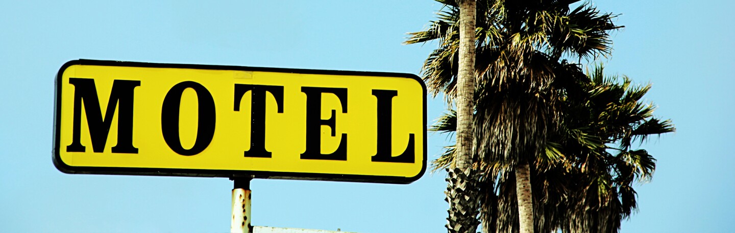 Motel sign with palm trees | Photo: Kevin Russ, iStockPhoto