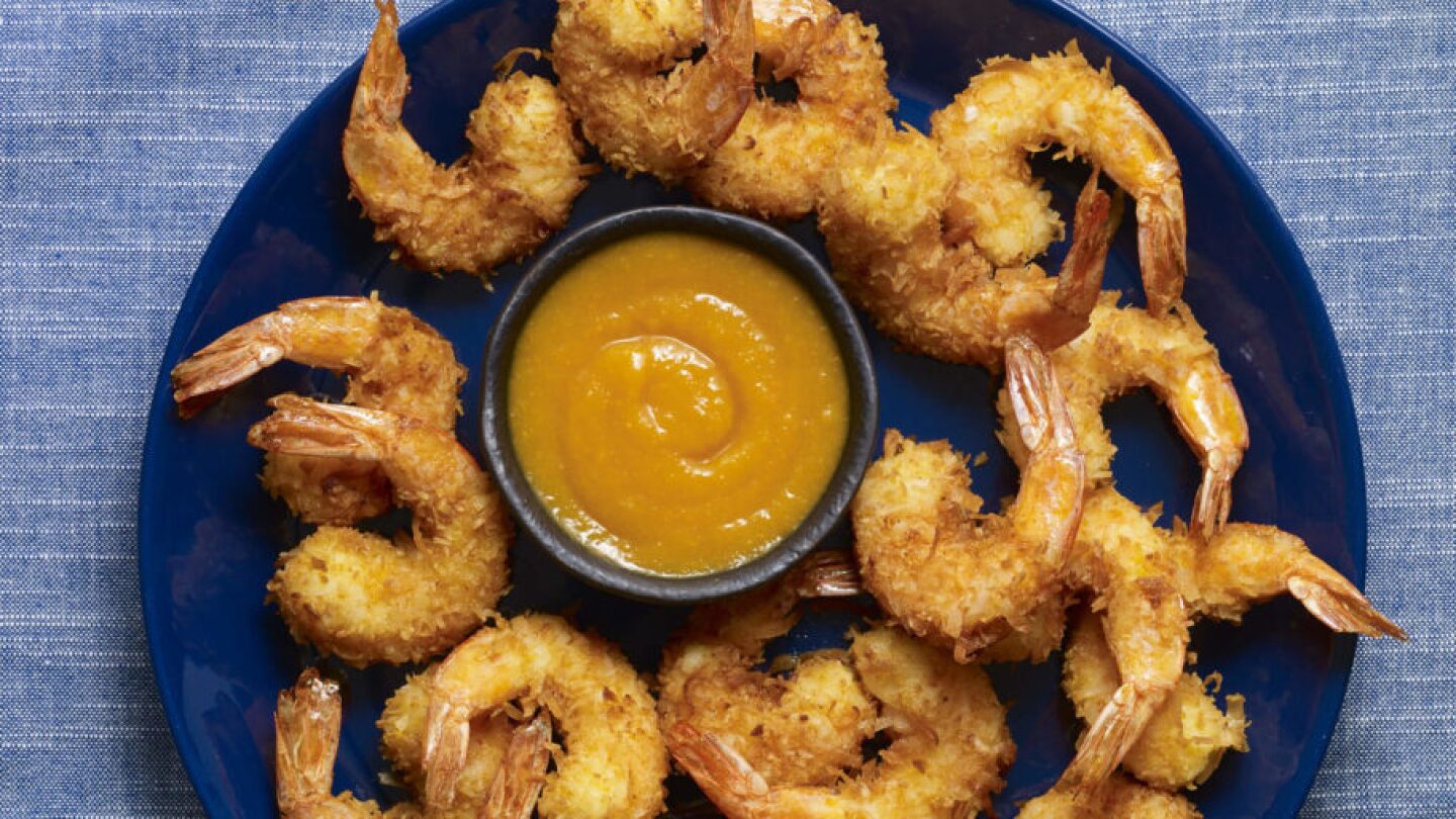 Coconut shrimp arranged on a blue plate with sauce in the middle. | From "Pati's Mexican Table: Season 5, Episode 5."