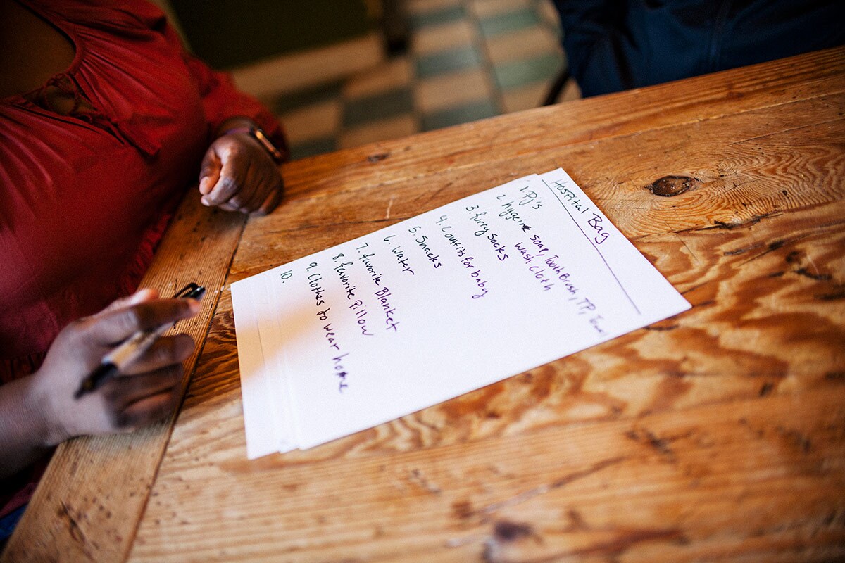 Christian Beckley writes a list of things Lashay Mallory should bring with her to the hospital including a bar of soap, washcloth, toothbrush, toothpaste and a pair of pajamas. | Samanta Helou Hernandez