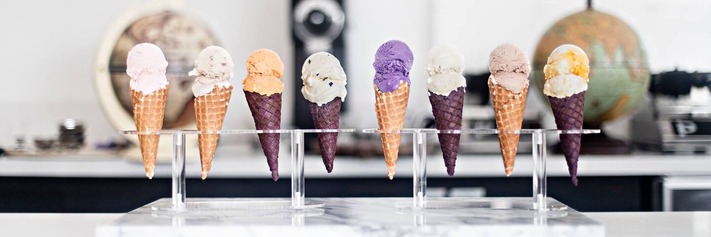 A row of ice creams in cones.