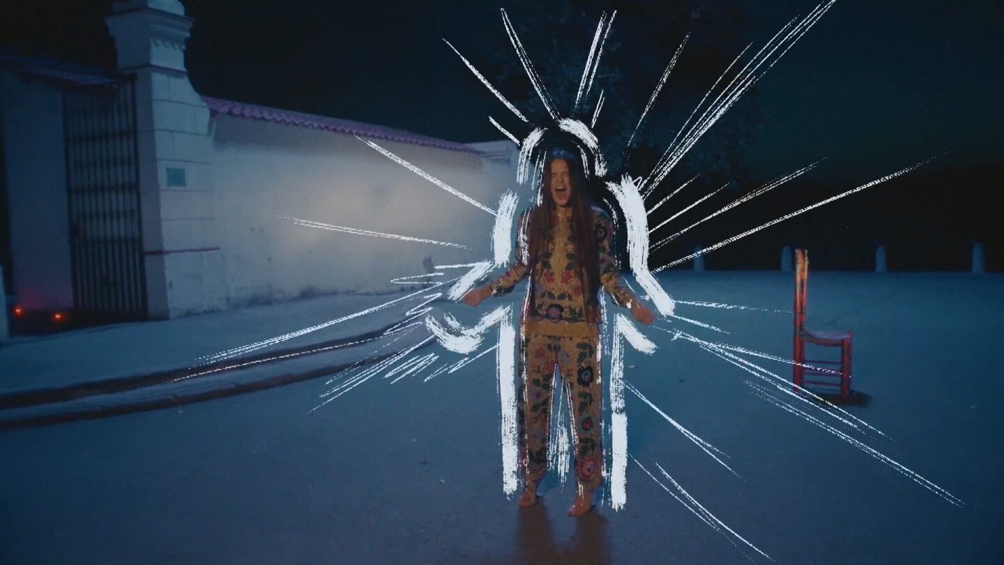 Music video still: Rosalía screams or sings with lines drawn around her