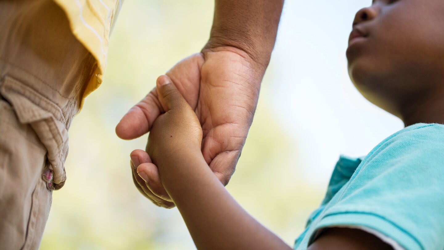 African American father and son holding hands