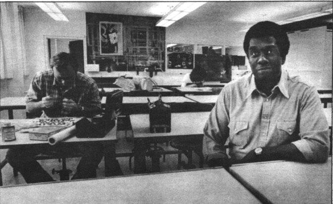 Archie Boston sits in his classroom with a student at California State University Long Beach.