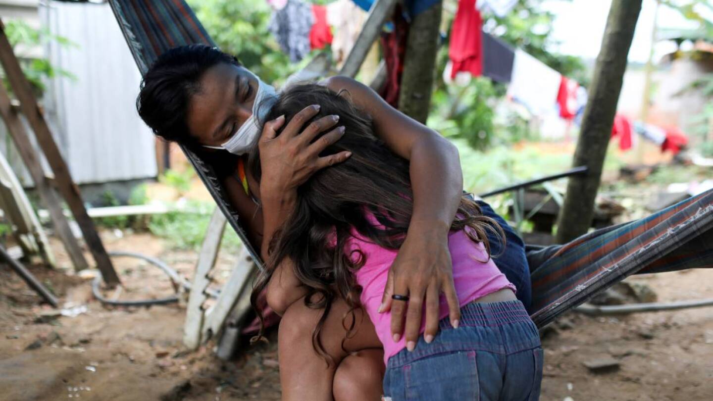 Vanderlecia Ortega dos Santos, 32, a nurse who has volunteered to provide the only frontline care protecting her indigenous community of 700 families from the COVID-19 outbreak, embraces her niece Maria Eduarda Ribeiro Ortega, 4.