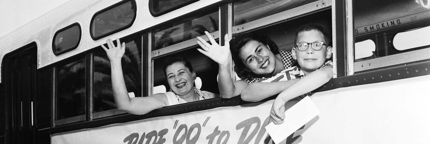 Councilmember Rosalind Wyman (center) waves out of a bus as she introduces a new bus line in 1958 with her constituents. | Los Angeles Examiner/USC Libraries/Corbis via Getty Images