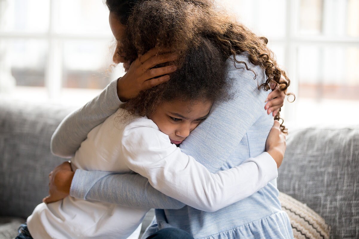 A woman holds a child tightly. | istock