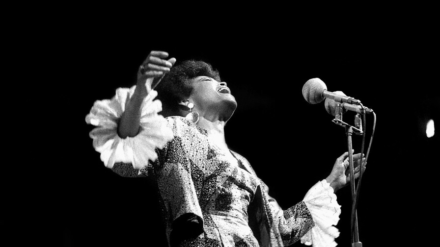 A singer belts out in song during a performance.