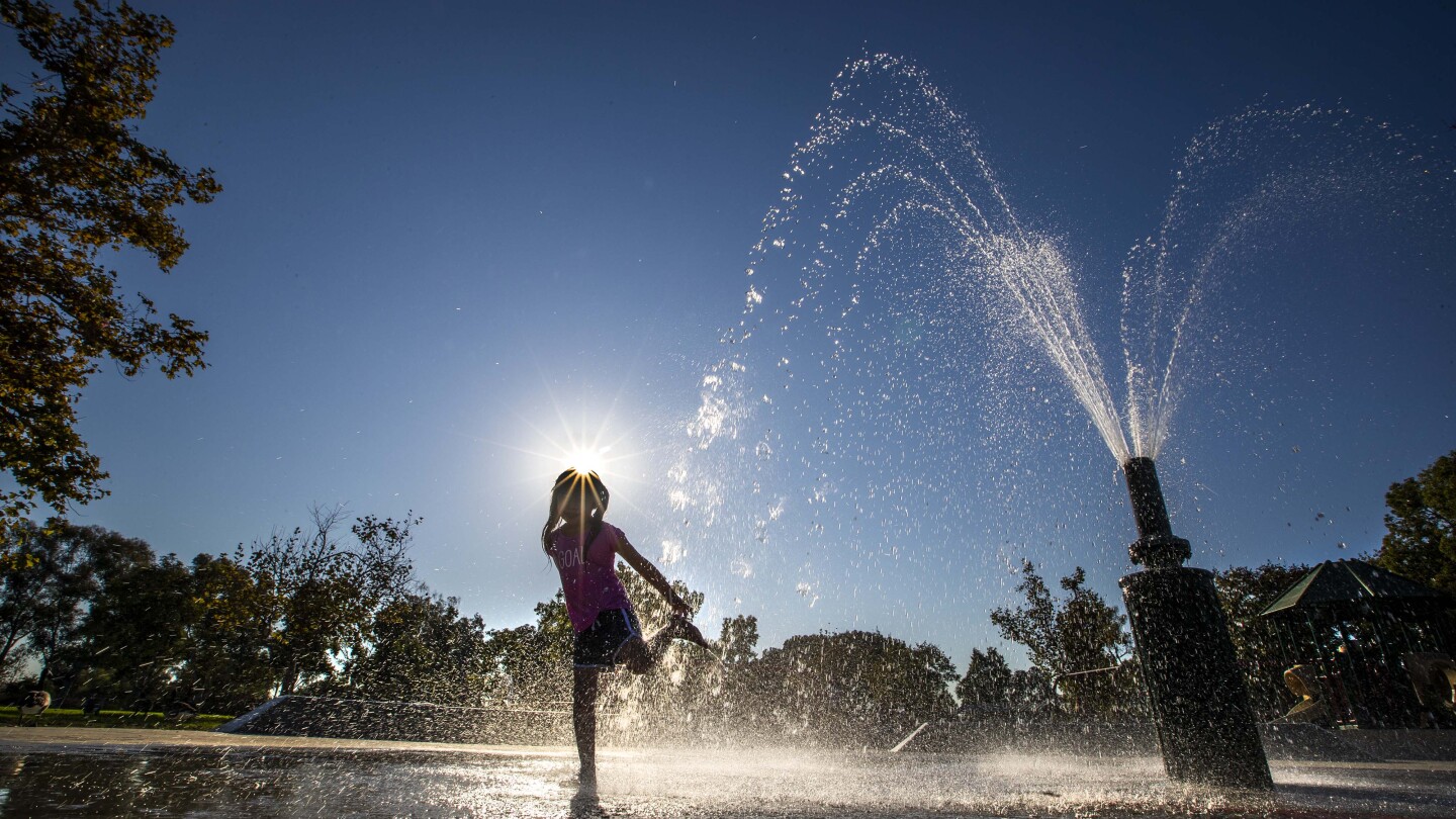 A girl playing in a fountain water at the park