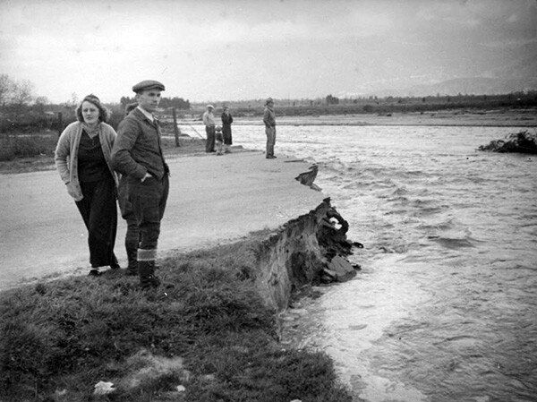 A group walks at the edge of a paved road that has collapsed. This could be either the San Gabriel River or the RÃo Hondo, both of which flooded in the early 1900s | Courtesy of the Los Angeles Public Library
