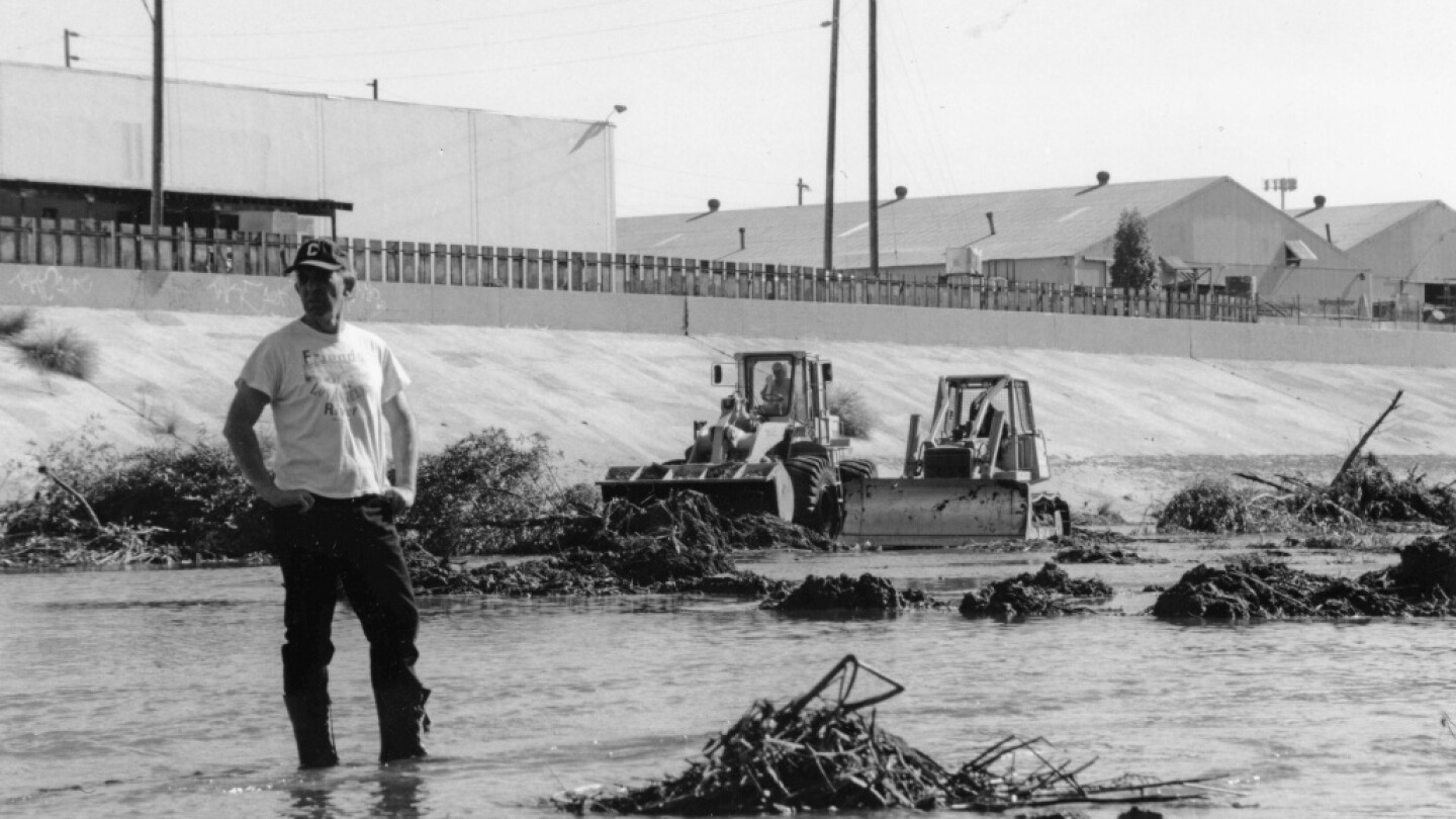 Lewis MacAdams, founder of Friends of the Los Angeles River, stands in the river as bulldozers clear vegetation from its channel in anticipation of heavy El Nino-driven rains, expected in the winter of 1997-98 | Blake Gumprecht, courtesy of FoLAR