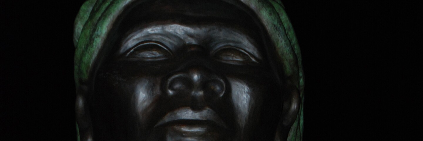 An image of Alison Saar's "Swing Low: Harriet Tubman Memorial" in Harlem at night | Jon Mannion/Flickr (CC BY-NC-ND 2.0)