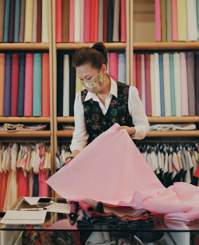 Laura folds a piece of fabric in her shop.
