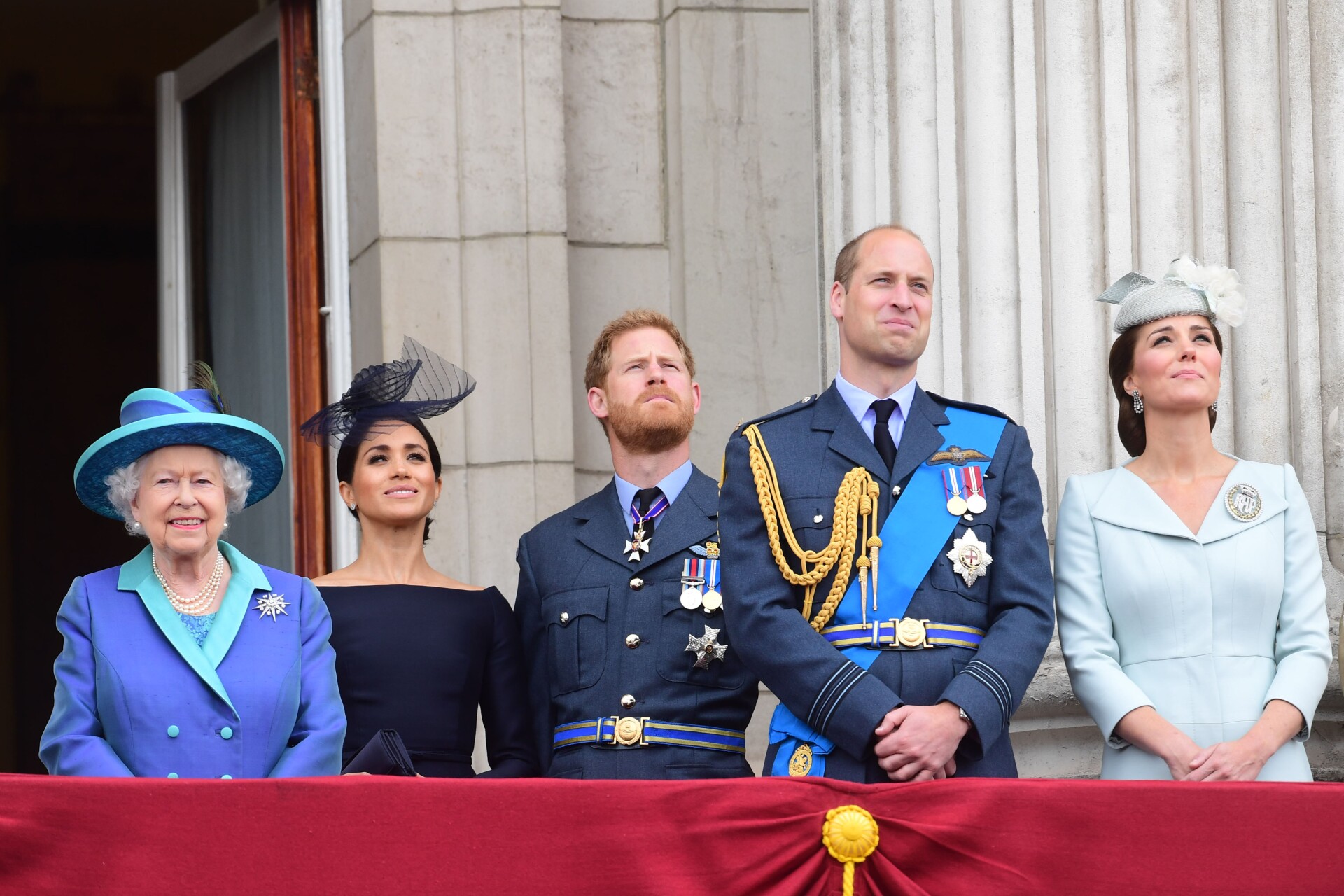 Queen Elizabeth II, Meghan, Duchess of Sussex, Prince Harry, Duke of Sussex, Prince William Duke of Cambridge and Catherine, Duchess of Cambridge stand on a balcony in formal attire at Buckingham Palace