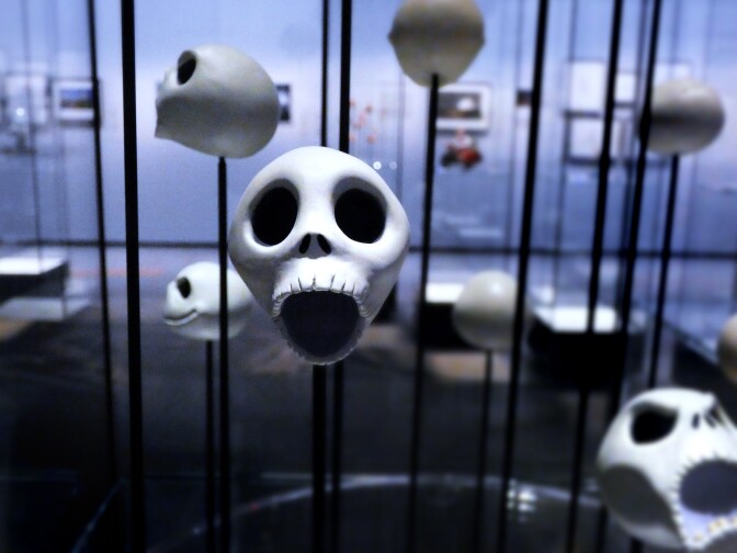 Various Jack Skellington heads are on propped up on black rods in a display at the Academy Museum. The face in the forefront holds a surprised expression.