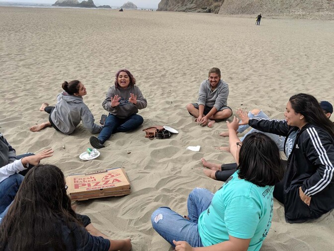 Californians for Justice youths eating pizza at the beach. It is a rare experience for many since most are juggling multiple responsibilities created by social and economic systems. | Californians for Justice