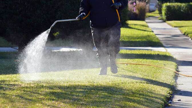 A pesticide applicator spraying a residential lawn | Photo: iStockPhoto