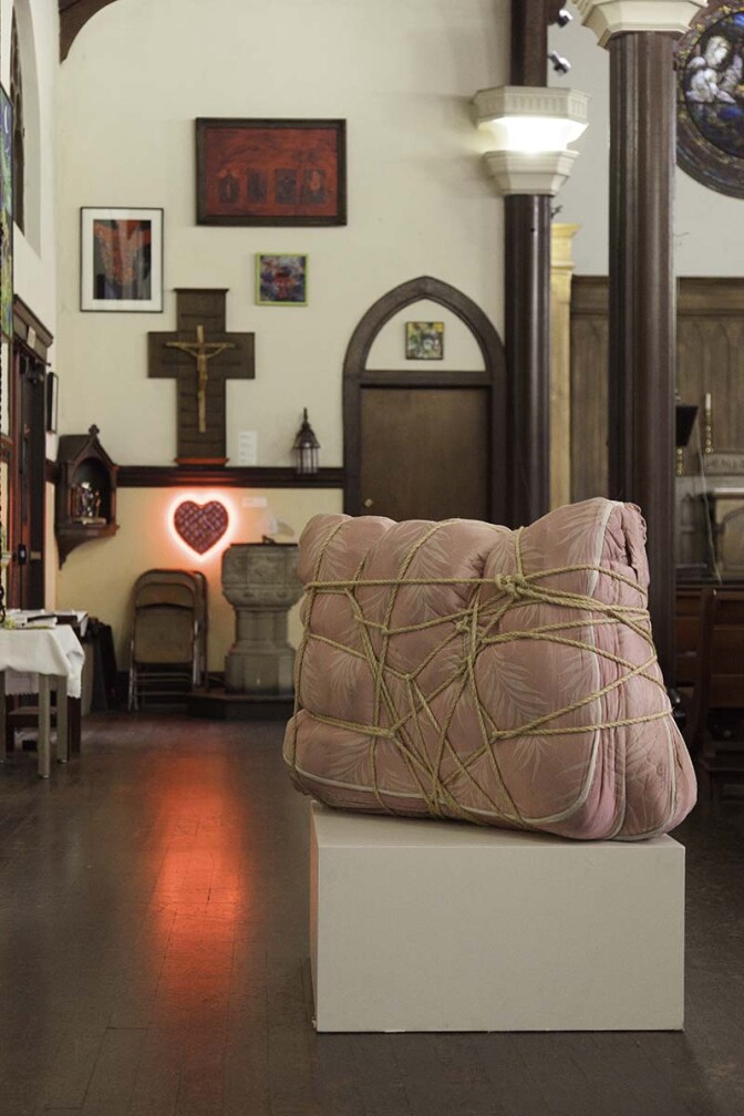 Camilo Ontiveros' Deportables, 2008, (mattress and rope) related to a series of works made from the belongings of deported immigrants (in foreground). | Courtesy of Ravi GuneWardena La Raza AB s9