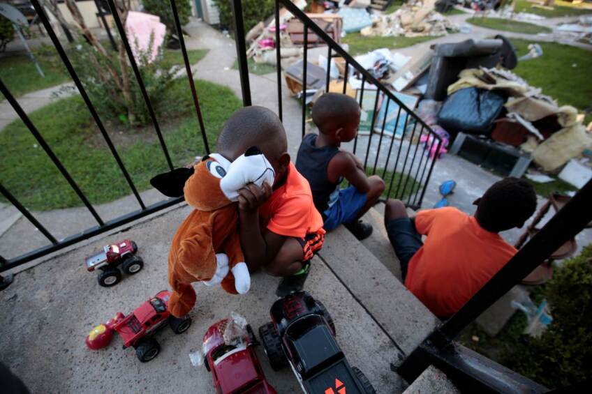 ARCHIVE PHOTO: From left, Kameron Smith, 4, Darius Smith, 9, and Deandre Green, 10, play with toys that they found in the piles of destroyed property at Crofton Place Apartments in the aftermath of Hurricane Harvey in Houston, Texas.