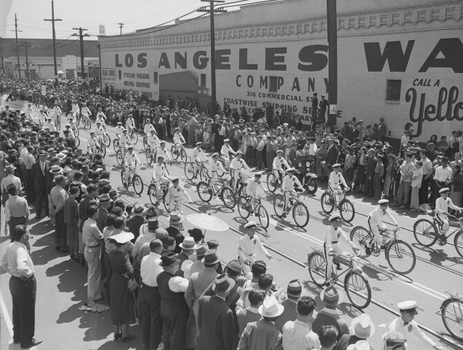 Men ride bicycles in a parade to celebrate the opening of Los Angeles Union Station.