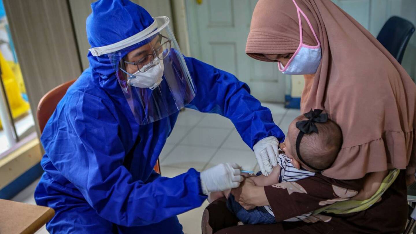 A medical staff member wearing personal protective equipment (PPE) vaccinates a baby, amid the coronavirus disease (COVID-19) outbreak, in Tangerang, near Jakarta, Indonesia May 13, 2020. | Antara Foto/Fauzan/ via REUTERS