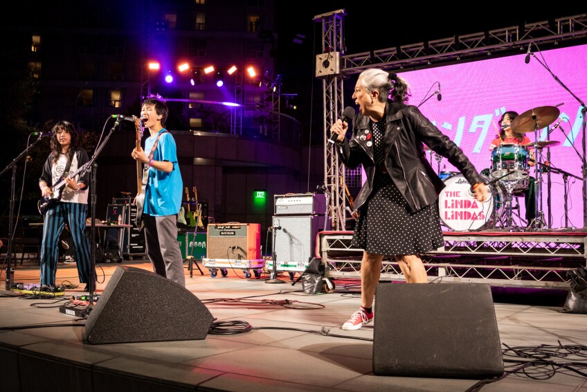 Alice Bag performs with the Linda Lindas onstage.