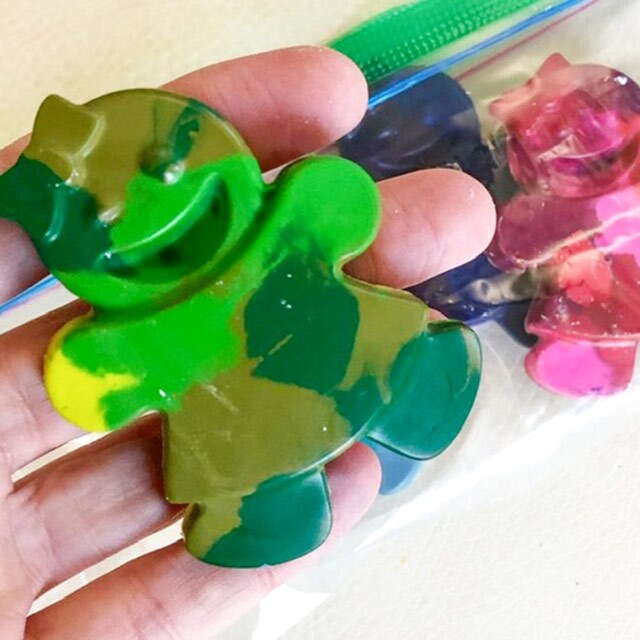 A swirled crayon in the shape of a doll with different shades of green.