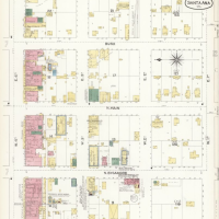 A blueprint of a city block with color-coded markings in the the squares. Residences housed by Chinese were marked in red on a fire insurance blueprint. 