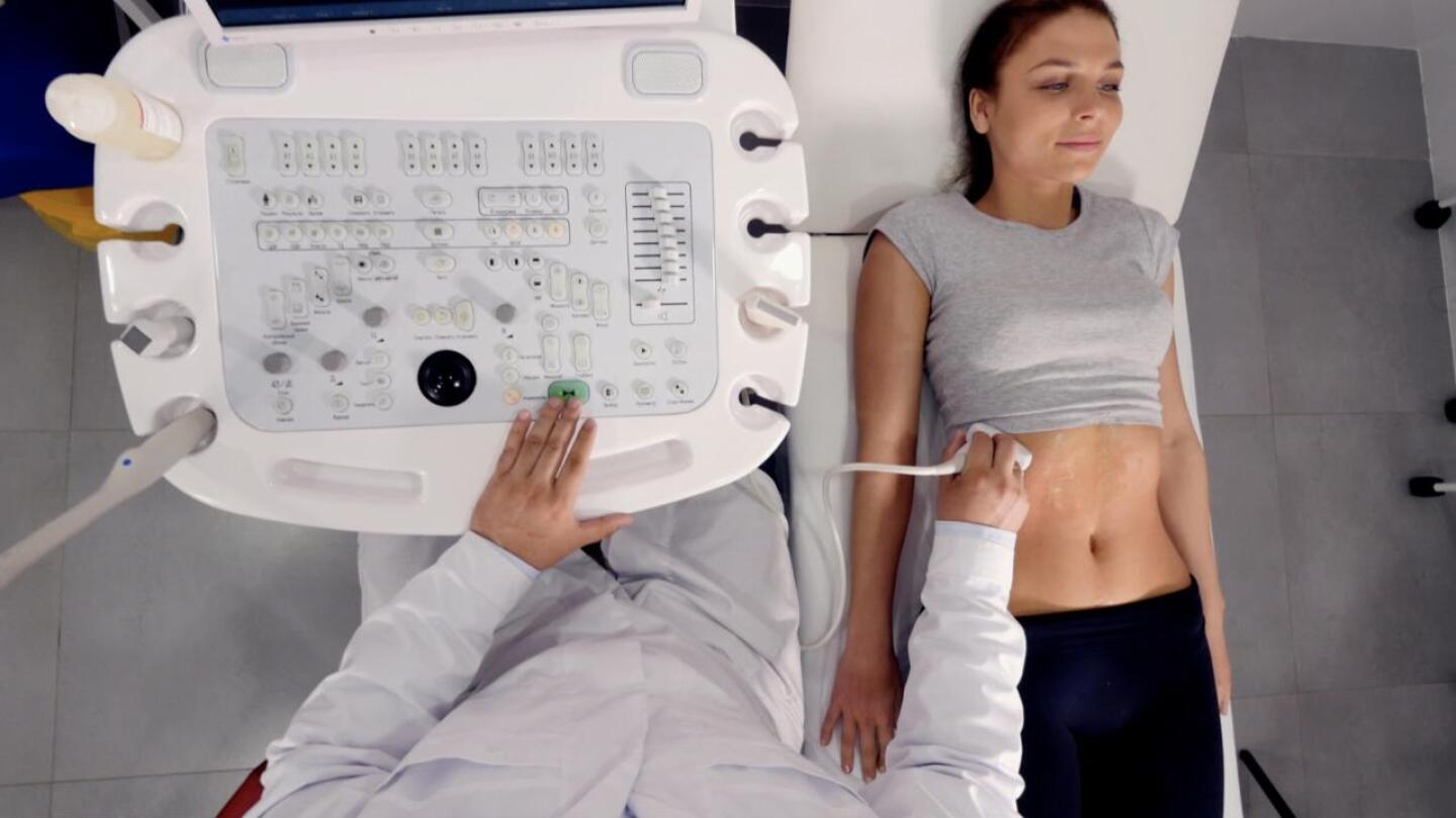 A woman's abdomen being examined with an ultrasound.