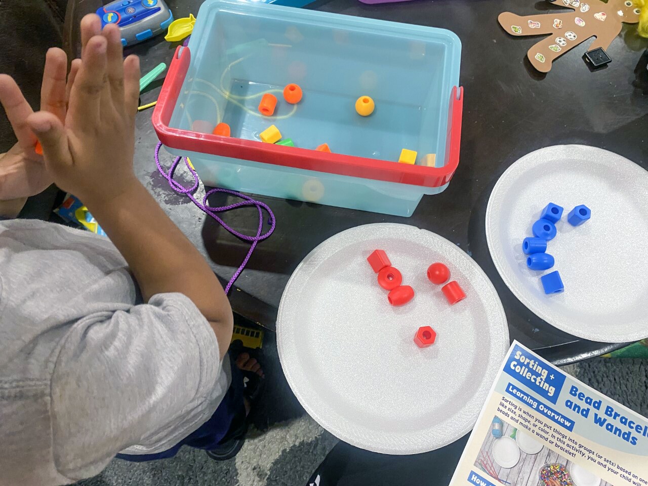 A child makes a bead bracelet