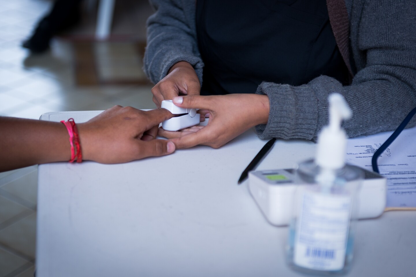Someone rests their finger in a pulse oximeter.