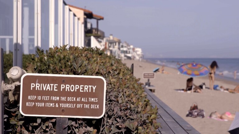 Private Property sign in foreground with beach behind it | Still from "Access Denied" on SoCal Connected