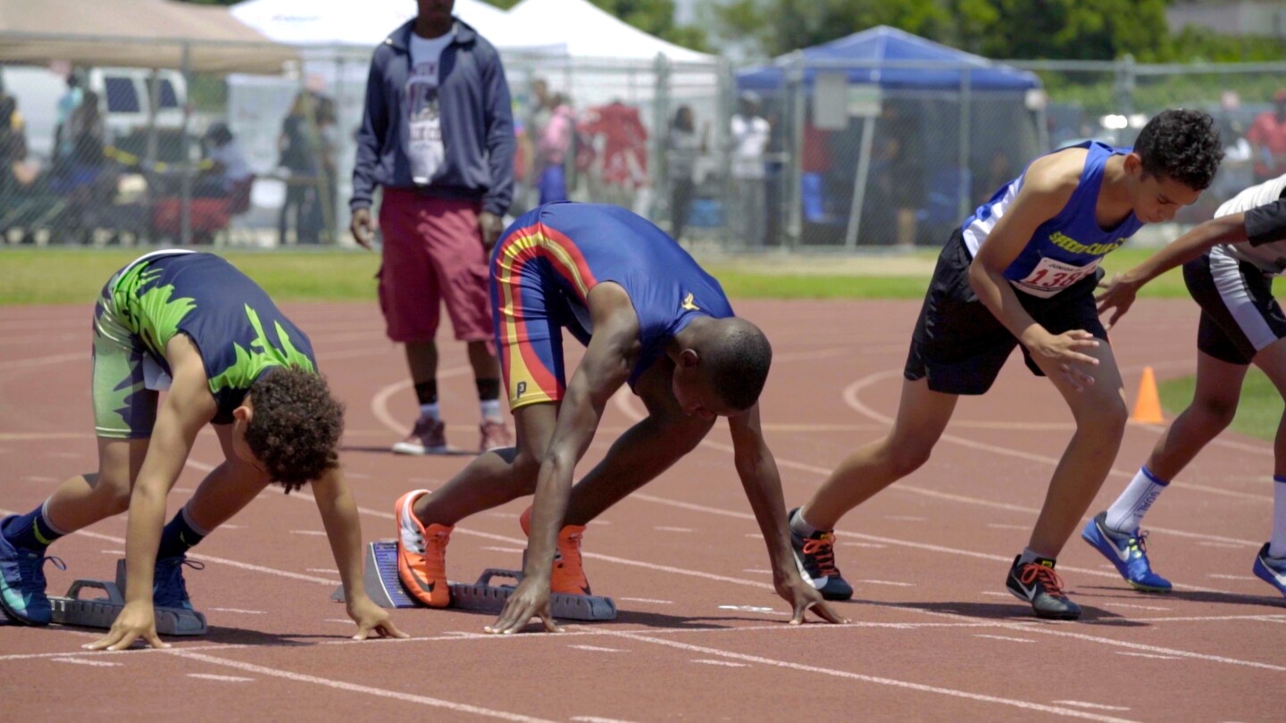 Boys about to run a track race, at the starting blocks | Still from "Born to Run", SoCal Connected